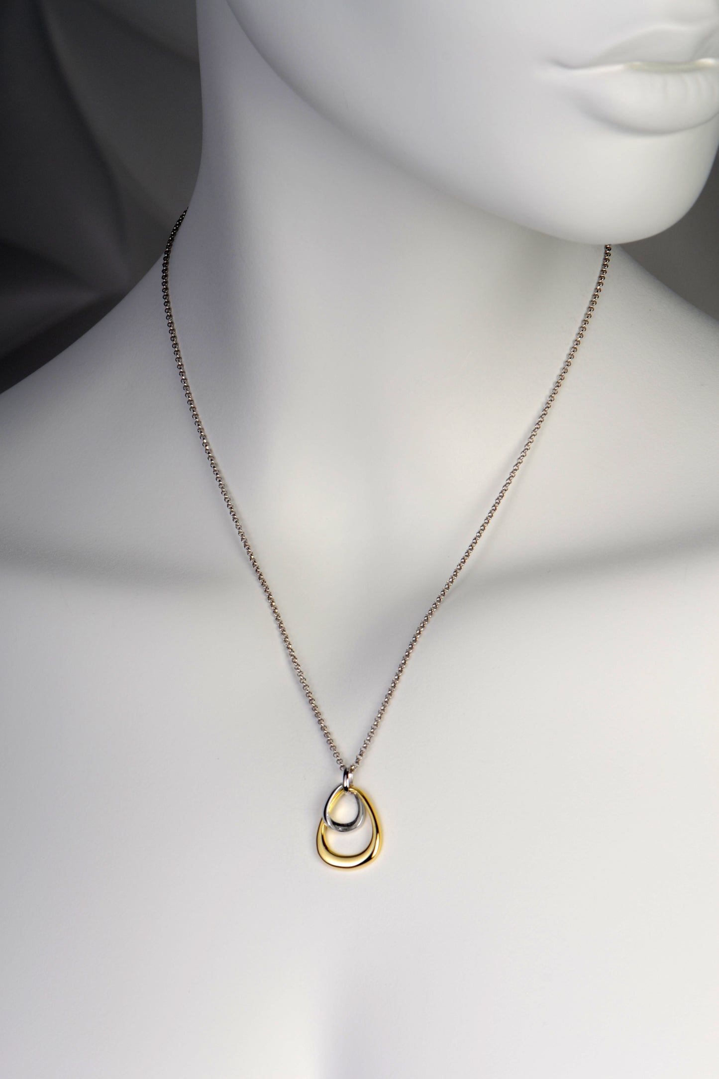 modern designer necklace with a small silver tear drop inside a larger gold vermeil tear dop shape hanging on a silver chain by jewellery designer Jorge Revilla