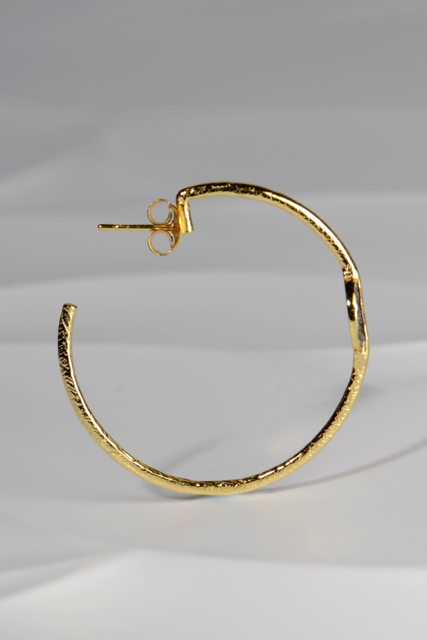 large designer hoop earrings in gold plated silver with an earring post and back fitting by jewellery designer Jorge Revilla