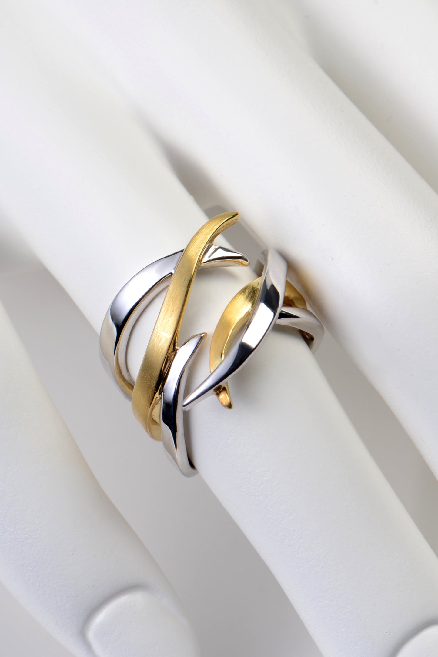 wide modern silver ring with gold vermeil details that have strands he cross over each other like roots growing from jewellery designer Jorge Revilla