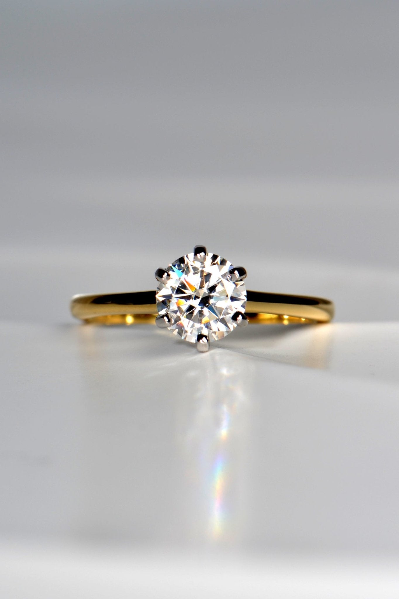 ethical six claw round brilliant cut one carat moissanite engagement ring with an 18ct yellow gold band and an 18ct white gold setting