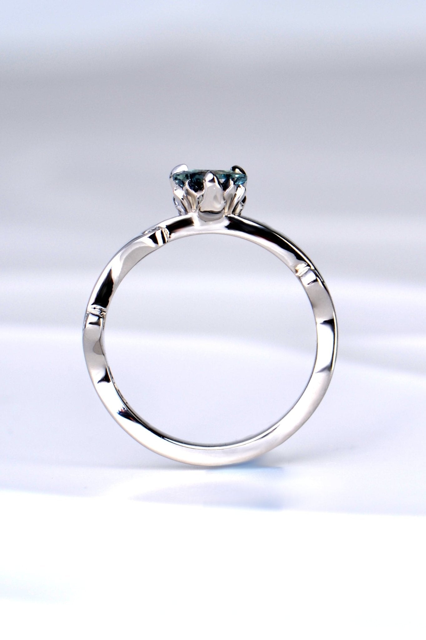 side view of the platinum and diamond heart cut Alexandrite colour change ring showing the sculptural design of the tiny flames that rise up to hold the gemstone