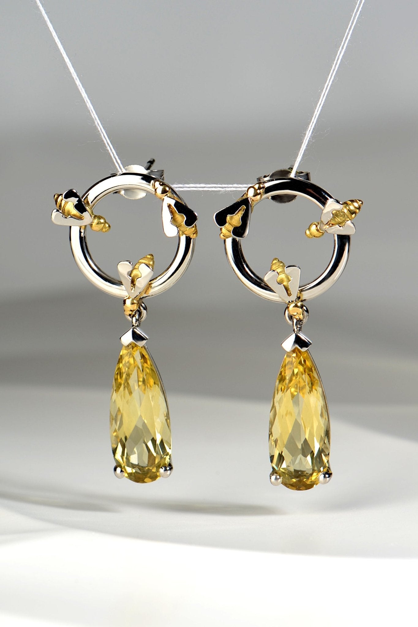 luxury fine jewellery platinum earrings that are one of a kind with long pear cut yellow beryl gemstones to look like dripping honey by contemporary jewellery designer Christine Sadler