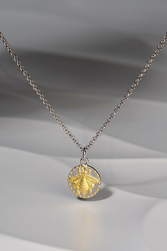 small circular pendant with a gold vermeil bee design on a silver chain - Jorge Revilla jewellery designer
