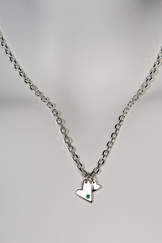 Sterling silver double heart necklace set with emerald displayed on white background from the From The Heart collection by Christine Sadler