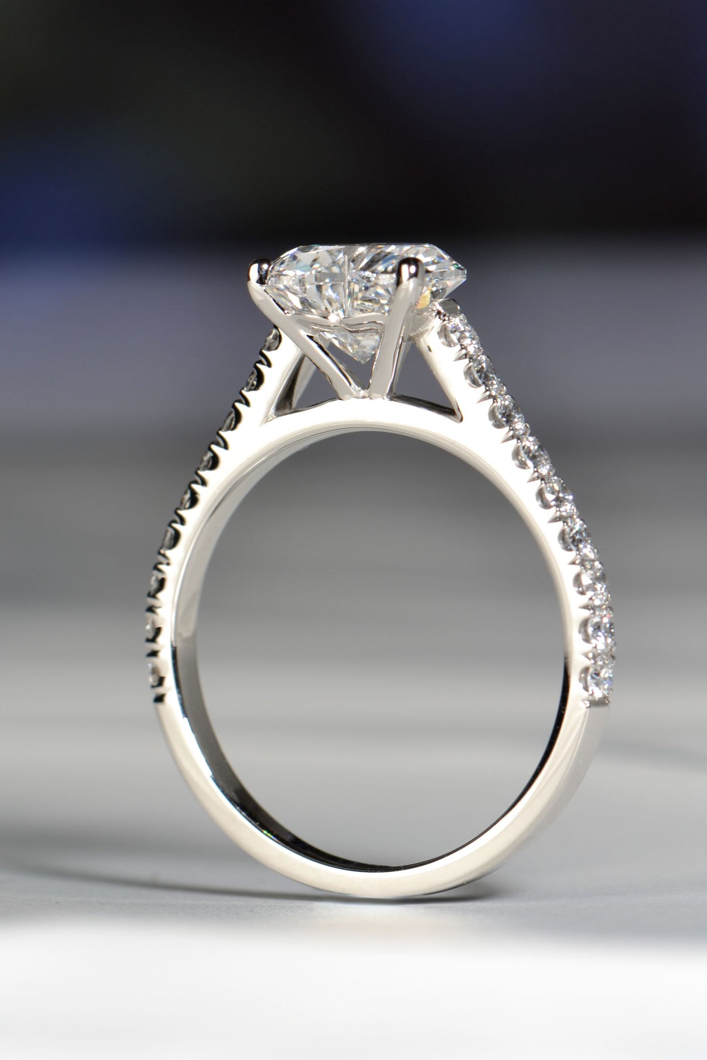 Side profile of a 2 carat heart shaped lab diamond engagement ring in platinum 950, showing the elevated setting, refined claws and hidden heart detail beneath the stone.
