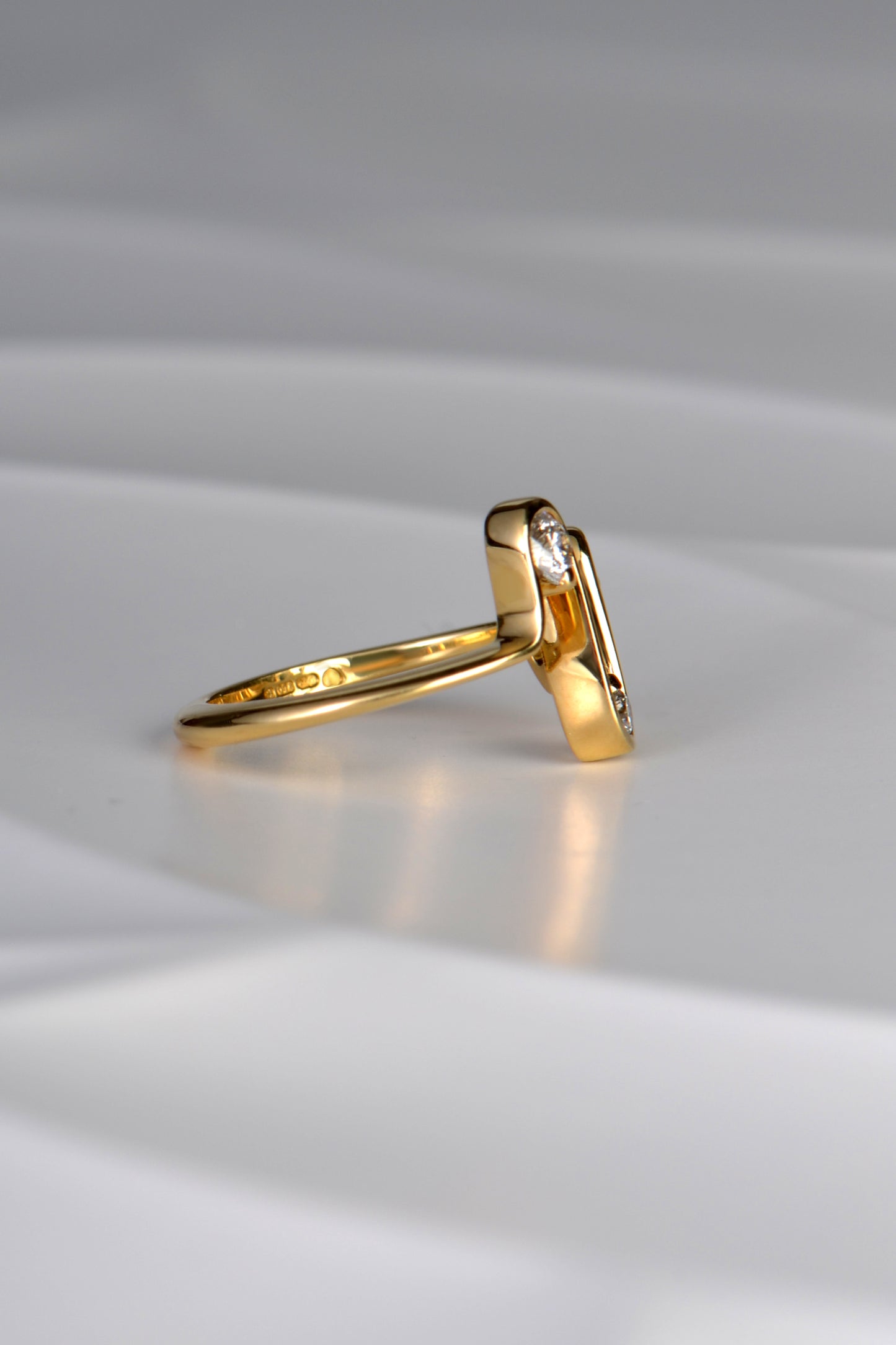 side view of the designer 18ct gold heartbeat ring showing that the waves at the front of the design taper to a straight line as it goes around the finger 