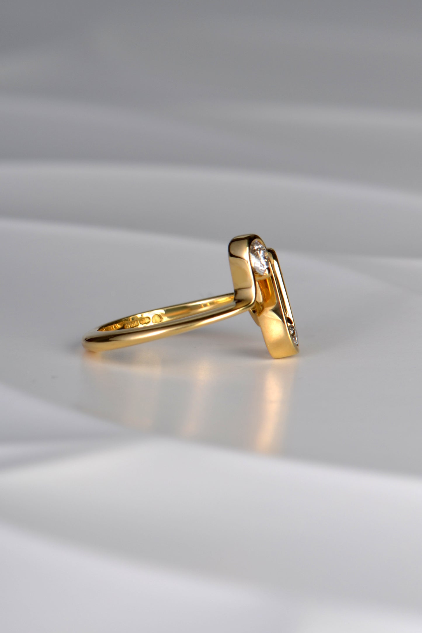 side view of the designer 18ct gold heartbeat ring showing that the waves at the front of the design taper to a straight line as it goes around the finger