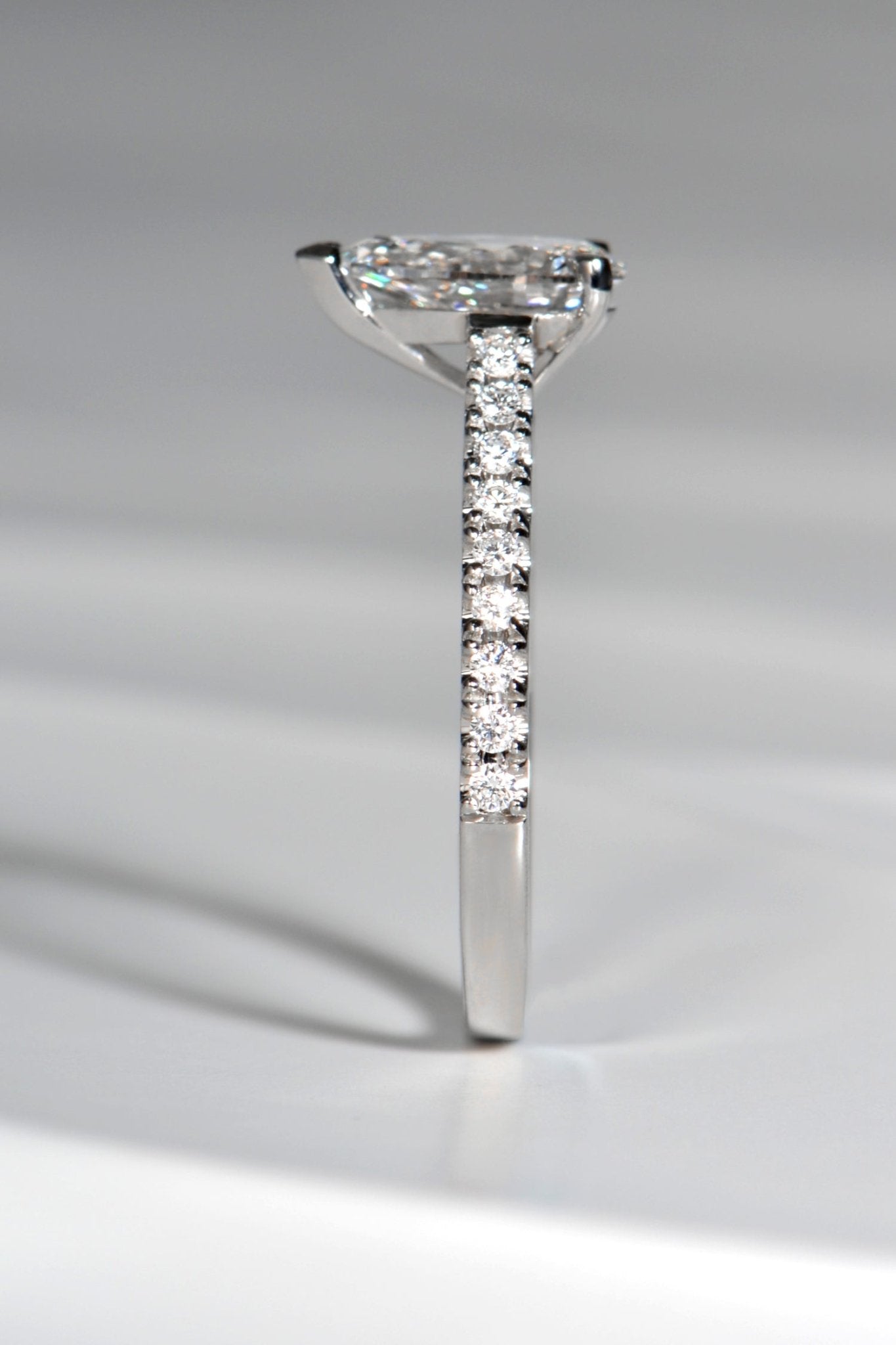 side view of modern pear cut diamond ring that is set high so a wedding ring can sit next to it. Available in lab grown or mined diamonds
