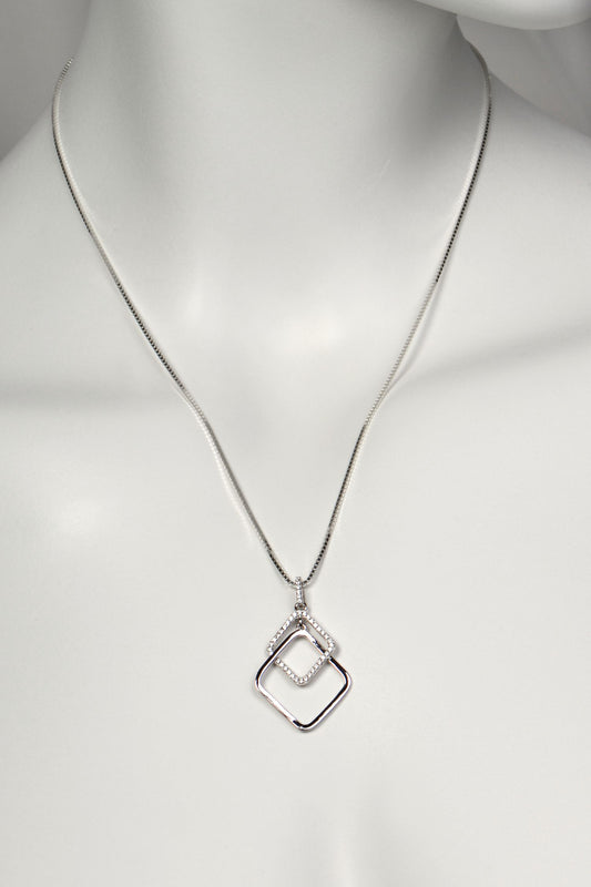 Silver sparkly necklace with a geometric pendant on a mannequin against a white background