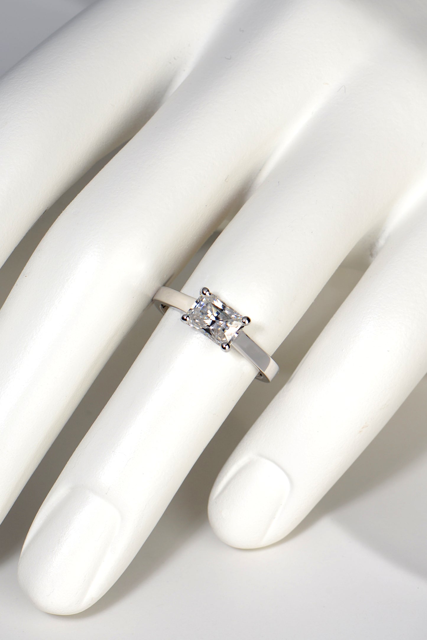 designer moissanite white gold ring on a finger to see how big it looks. It covers approximately half the finger with a quarter of the ring visible on either side of it. It looks impressive in size.