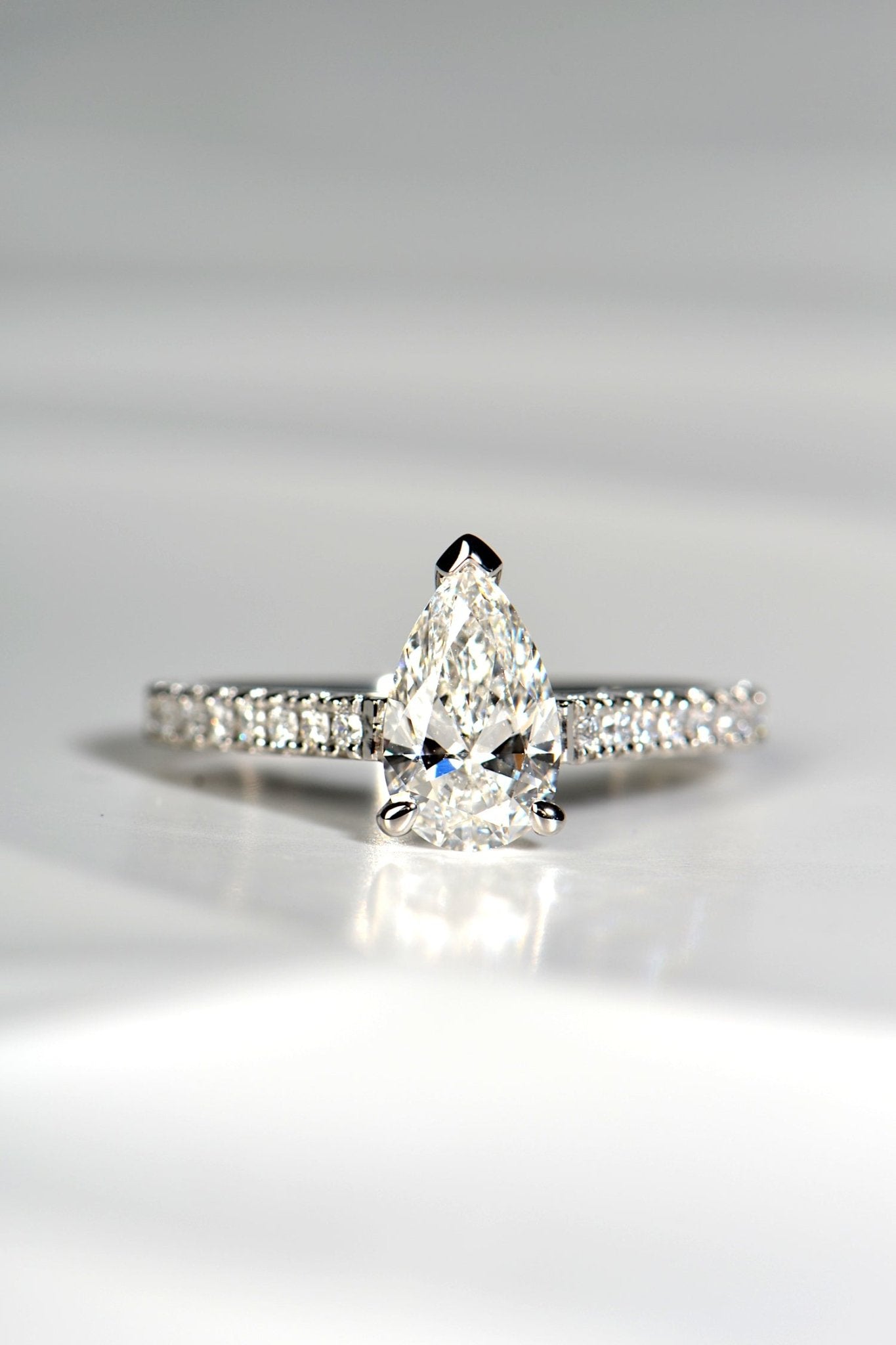 pear cut diamond engagement ring with diamonds in the shoulders.
