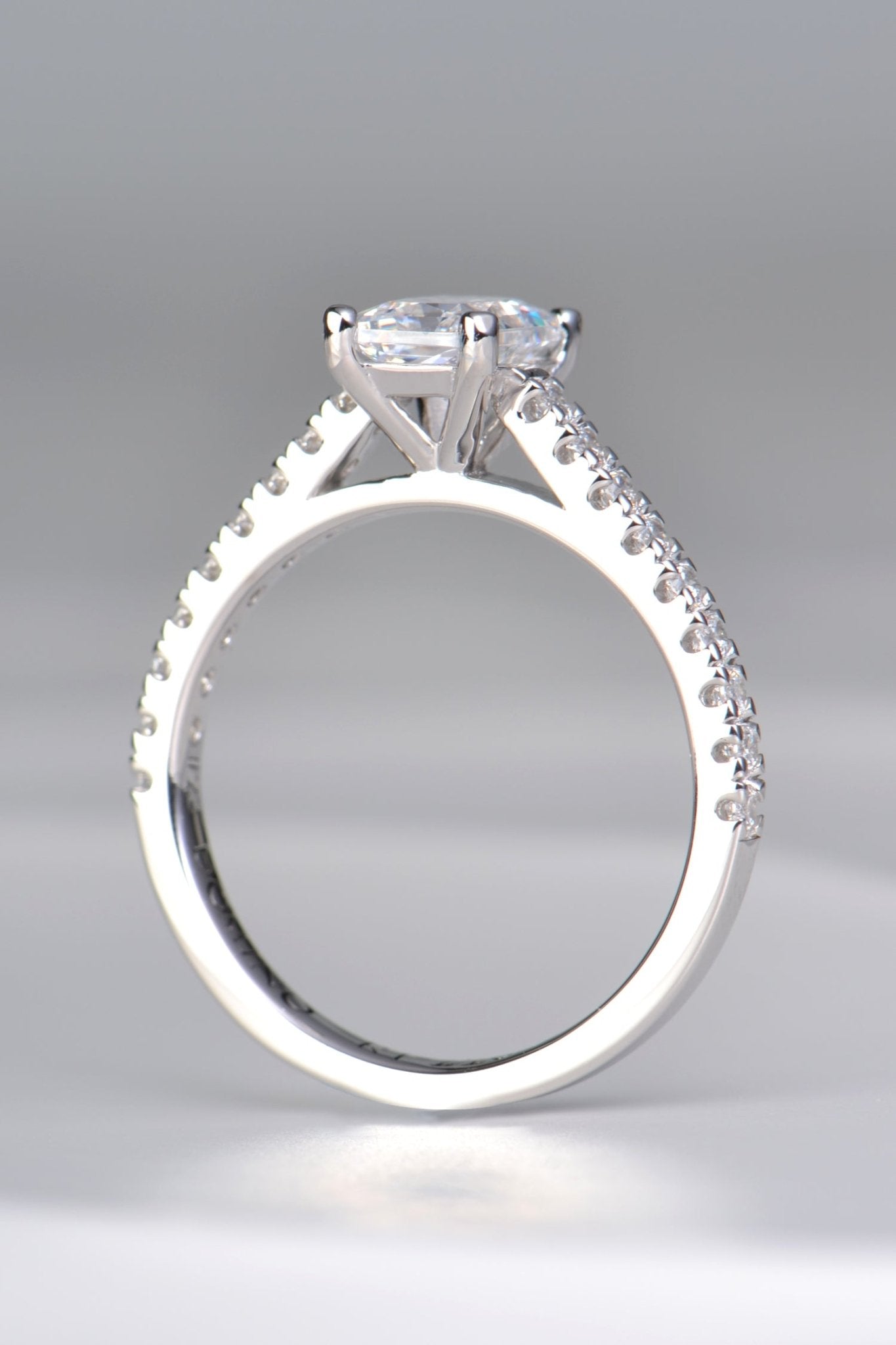 modern emerald cut diamond engagement ring with diamonds in the shoulders made in the UK