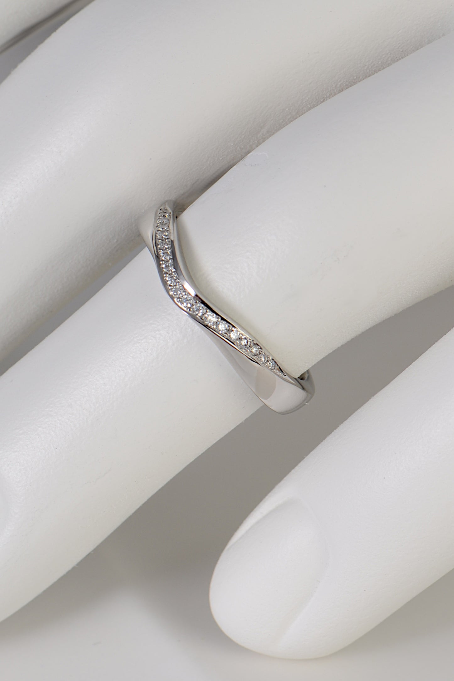 stunning platinum and diamond wedding ring that dips in the middle so a stone set engagment ring can sit next to it.