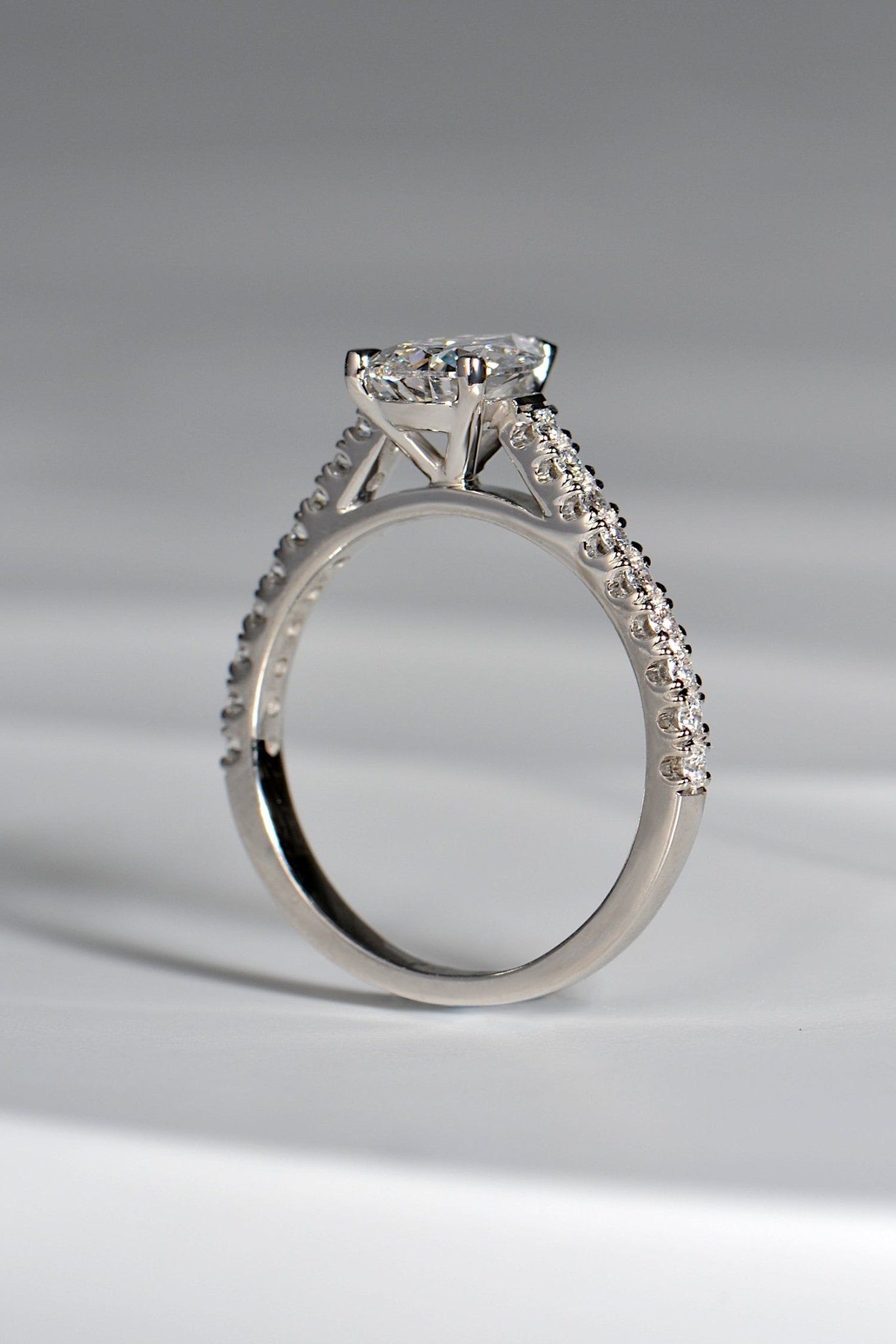 snuggle fit pear cut diamond engagement ring in platinum with diamonds in the shoulders