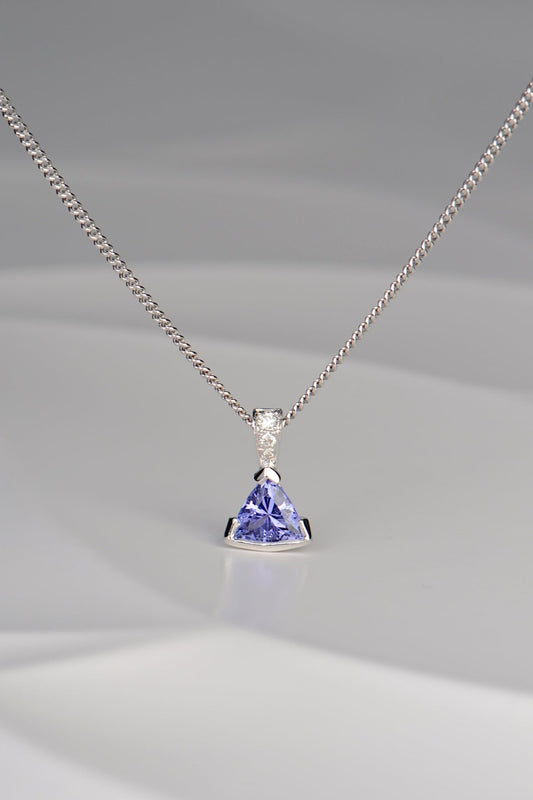 modern white gold necklace with three diamonds and a triangular tanzanite hanging below them by jewellery designer Christine Sadler