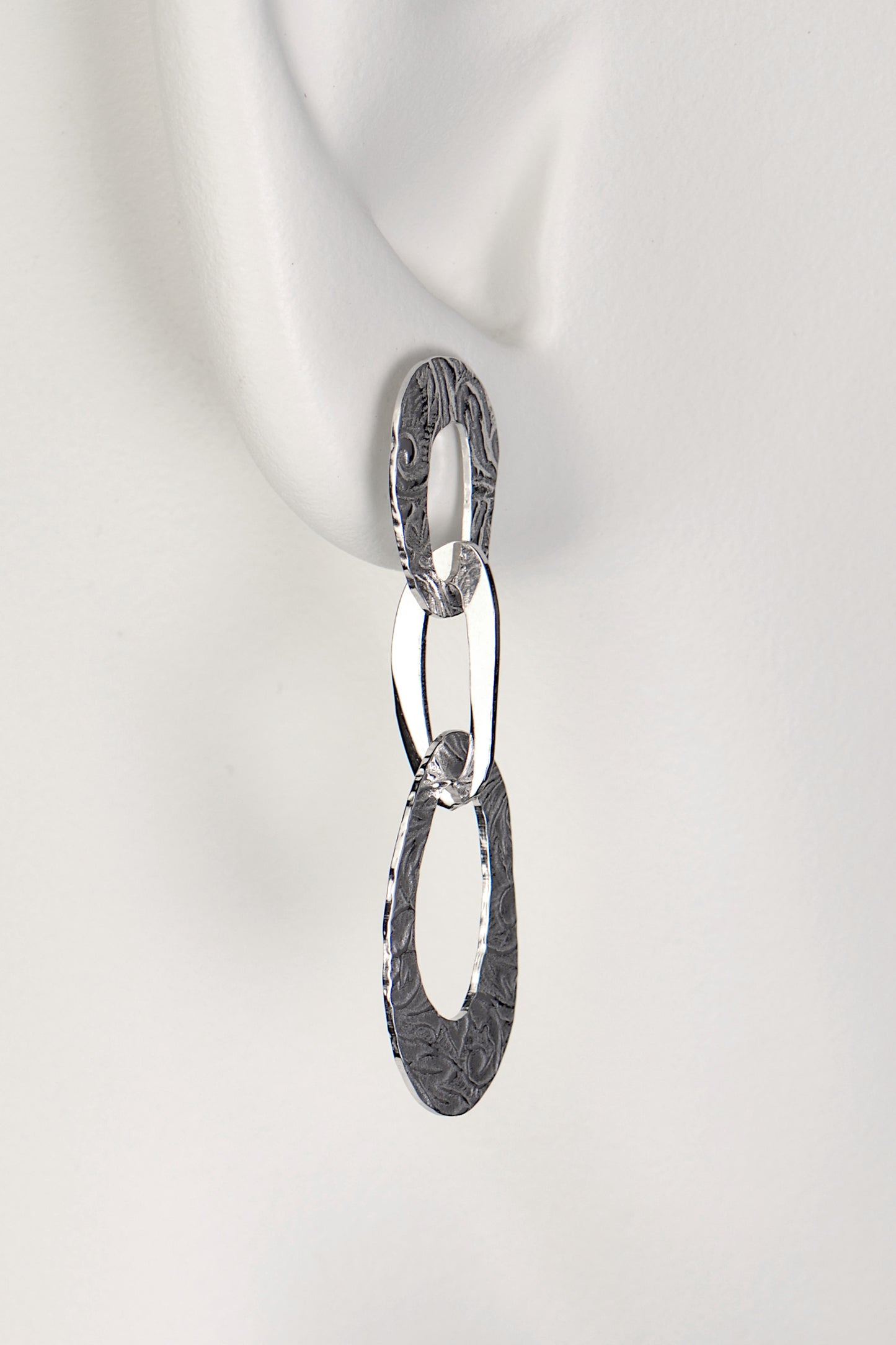 three interlocking organic oval links form a long drop silver earring with a textured pattern on the links inspired by the natural beauty of frost patterns - Christine Sadler