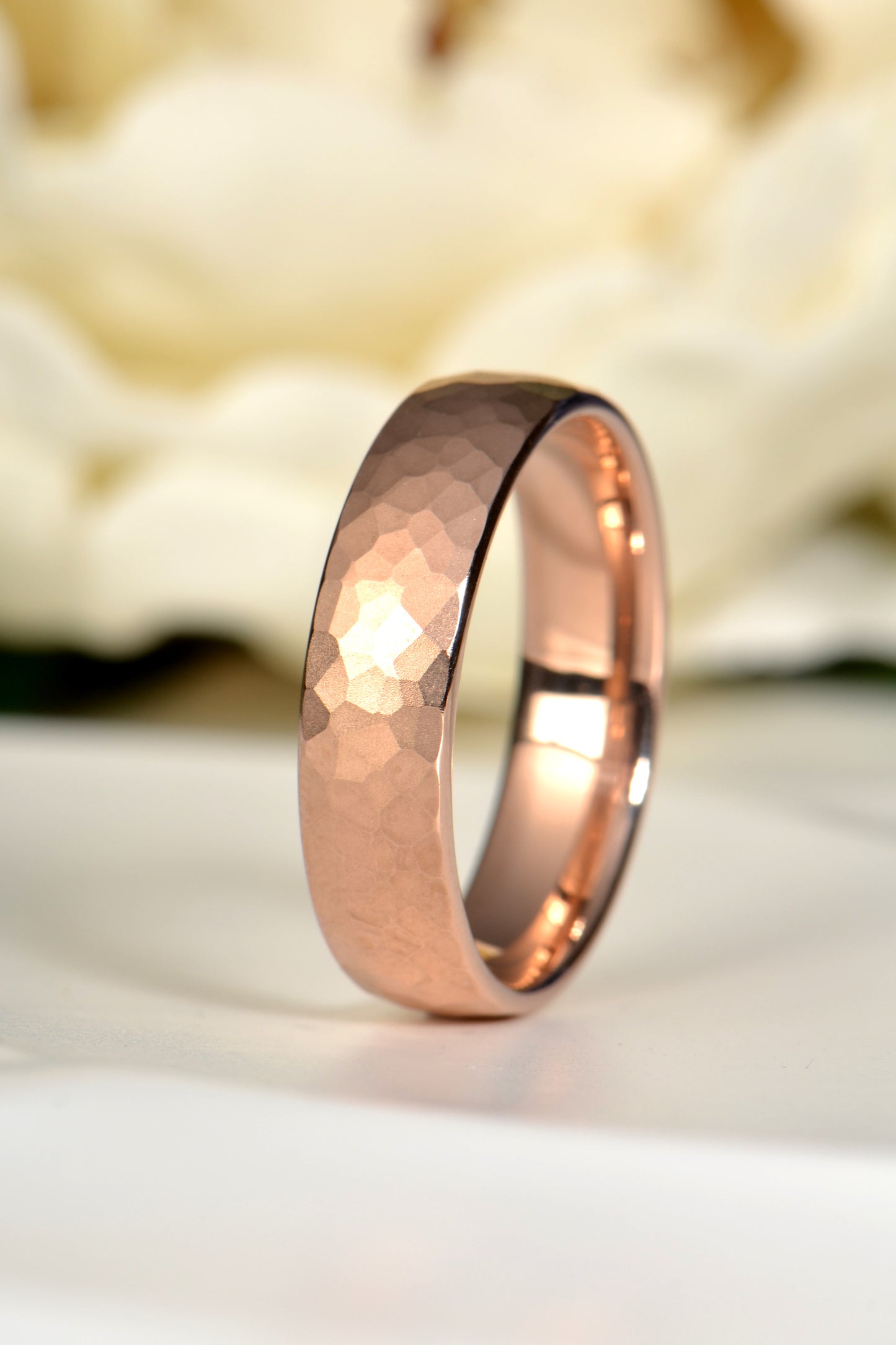 18ct rose gold gents wedding ring with hammered matt brushed finish, photographed with a white rose symbolising timeless love – handmade in the UK by Christine Sadler Unforgettable Jewellery