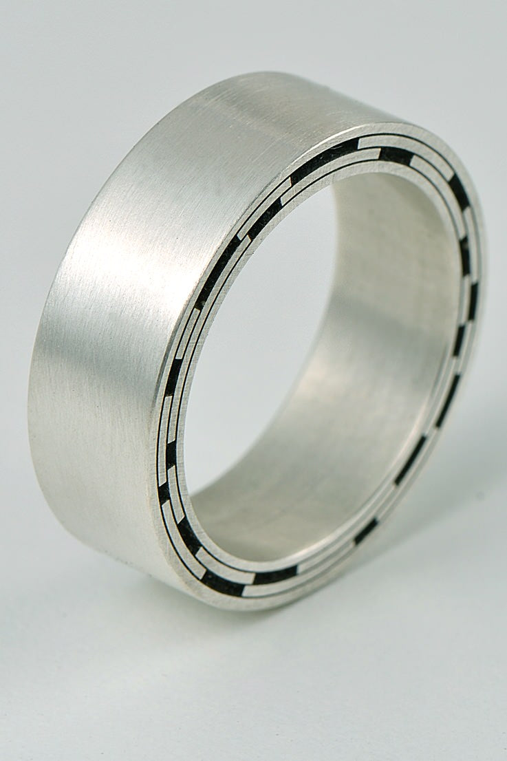contemporary designer silver ring cut by engineering tools to a design inspired by star trails