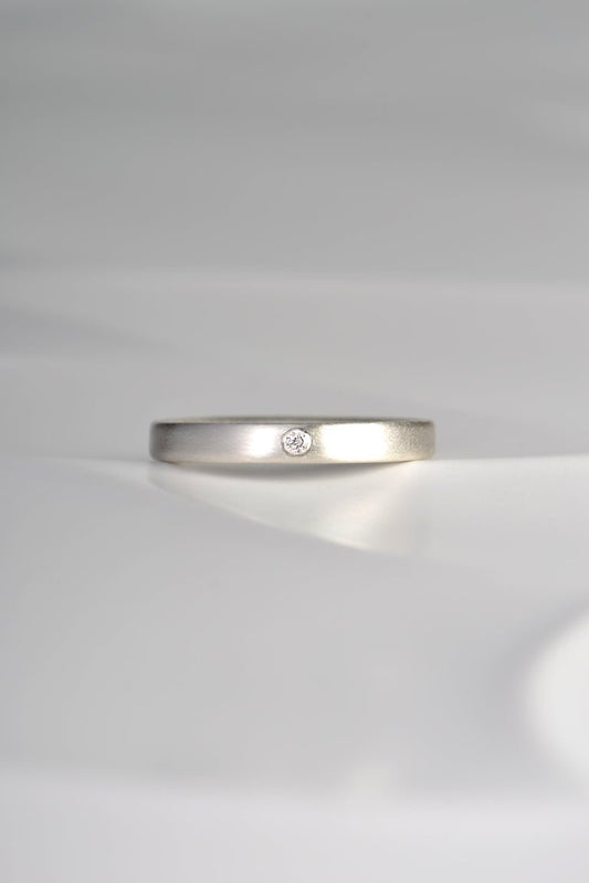 modern plain silver ring set with a diamond and matt finished
