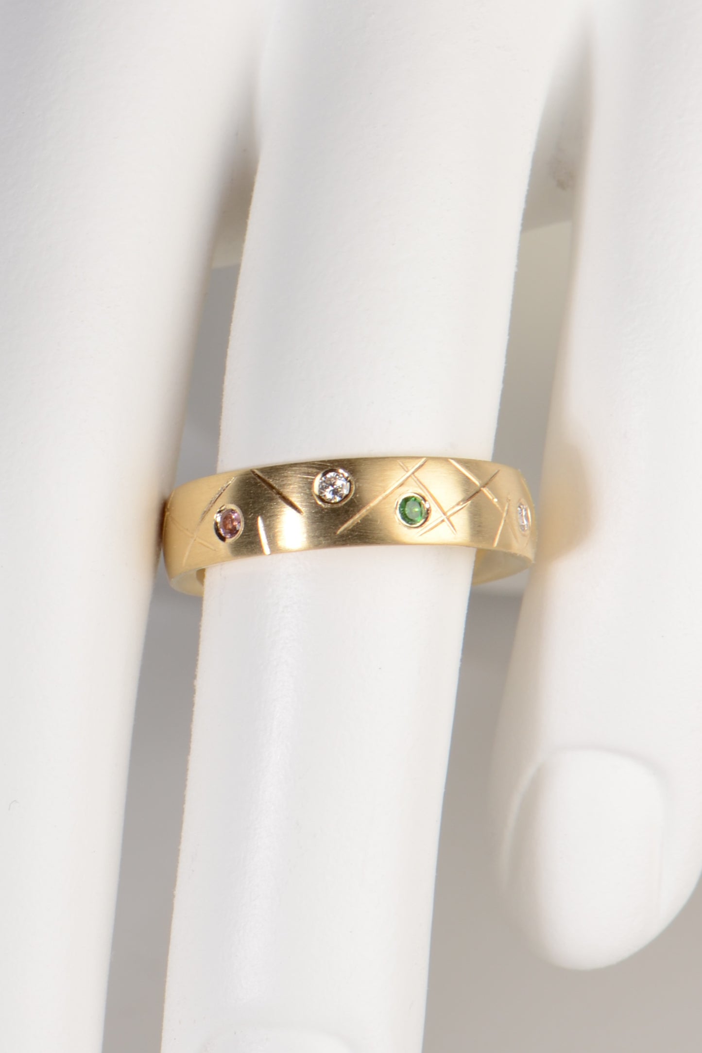 a 5mm wide gemstone ring with different coloured stones that is ideal as a birthstone ring or family ring or as a wedding or eternity ring by jewellery designer Christine Sadler who allows people to customise her designs to make them more personal