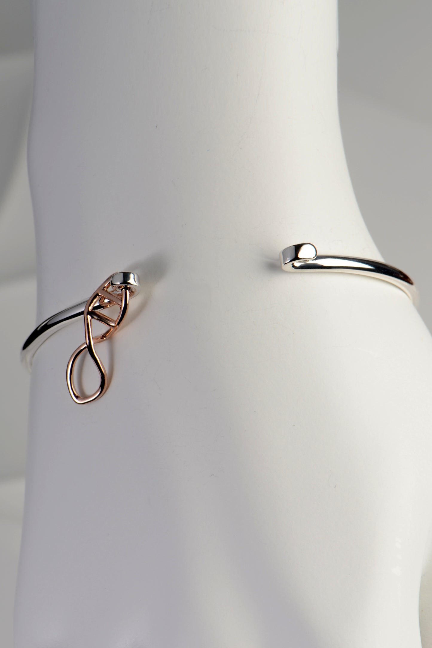 Silver Life bangle with rose gold DNA link shown on mannequin wrist toshow how it opens