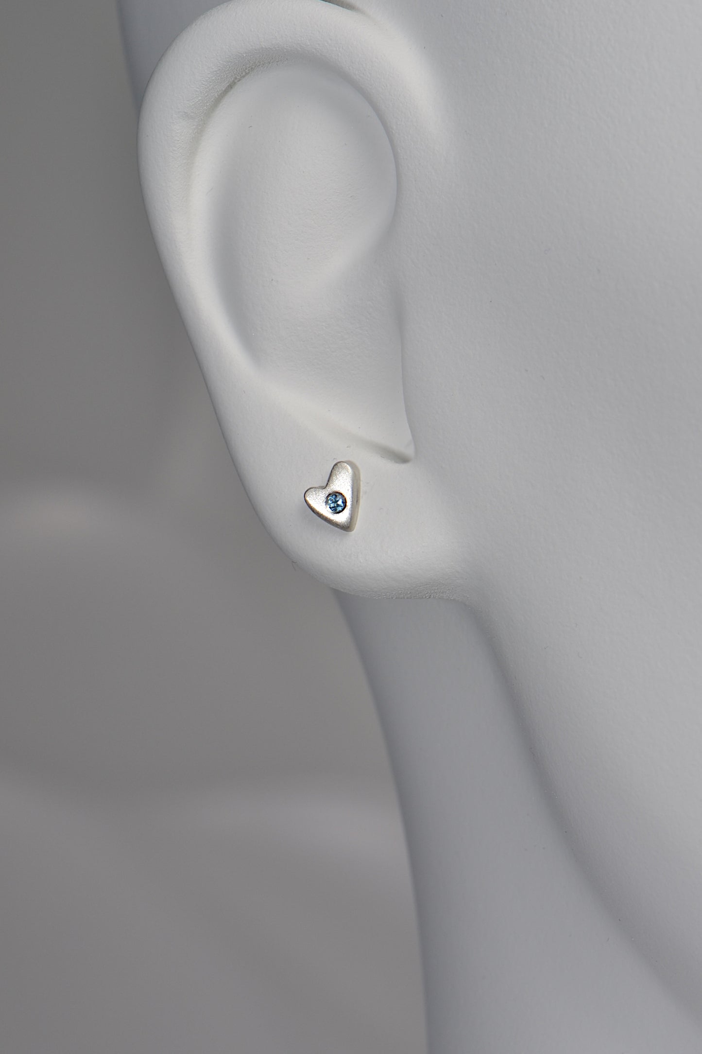From the Heart aquamarine earrings in matt silver shown on a white mannequin for size and scale