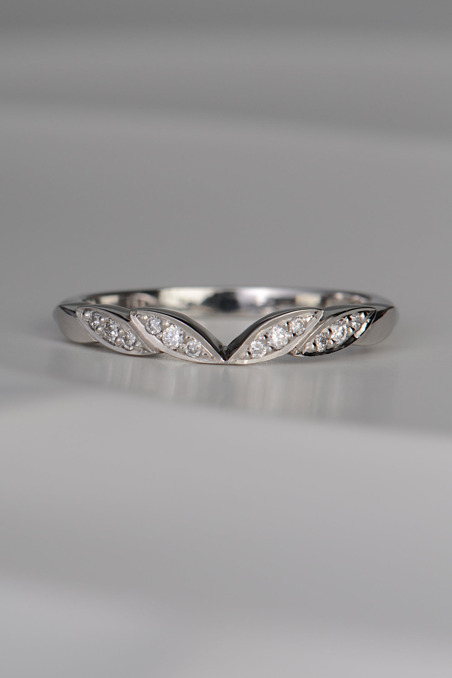 handmade platinum wedding ring with four leaf details at the front with three diamonds set in each leaf. Handmade in the UK