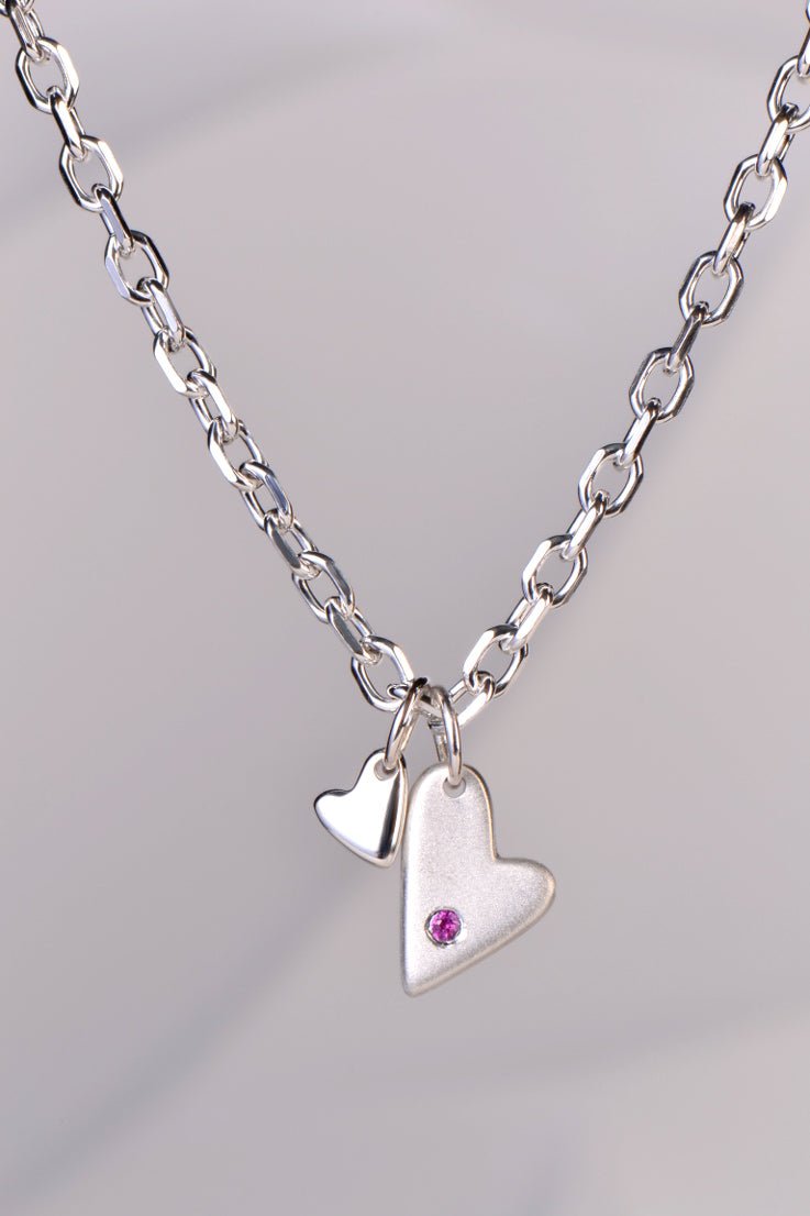 Sterling silver double heart necklace with pink sapphire displayed on white background from the From The Heart collection by Christine Sadler