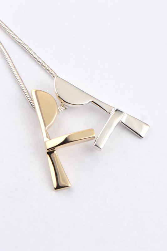 Modern unique necklace design that moves with two people that kiss and cuddle, one gold and one silver by jewellery designer Christine Sadler