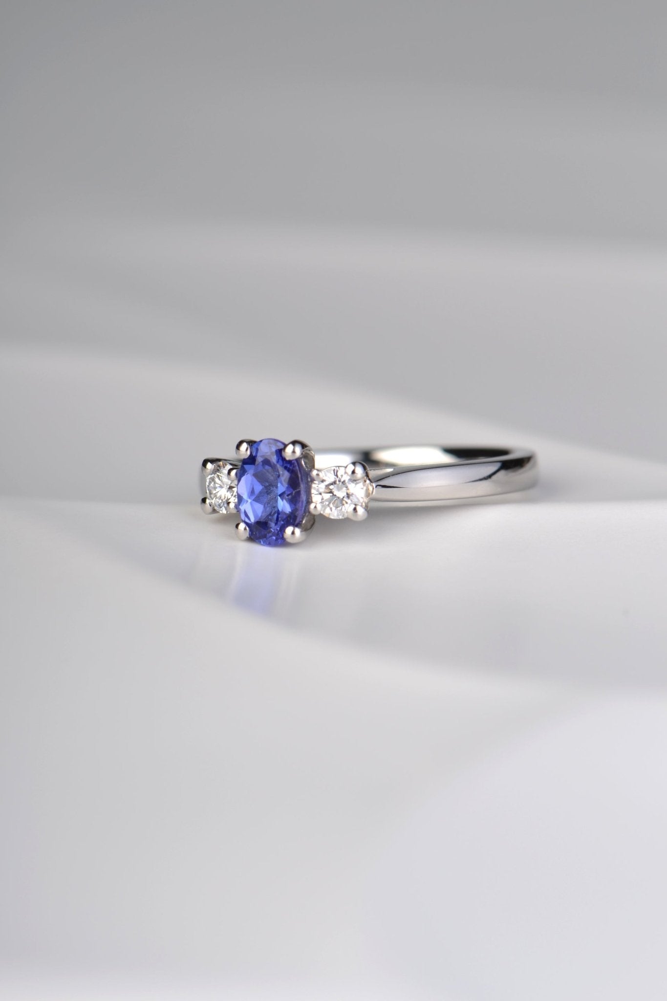 oval cut tanzanite ring with two round diamonds. This platinum engagement ring is handmade in the UK