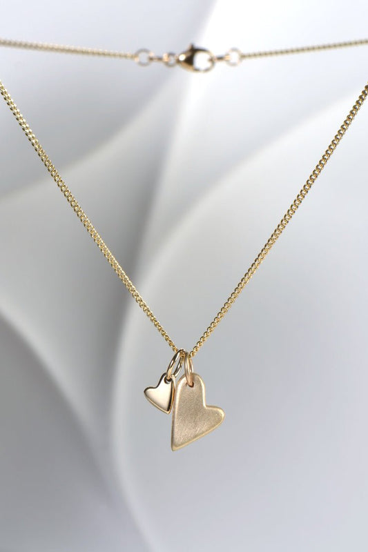 9ct yellow gold double heart necklace with brushed and polished finishes on a 45cm curb chain from the From The Heart collection by Christine Sadler