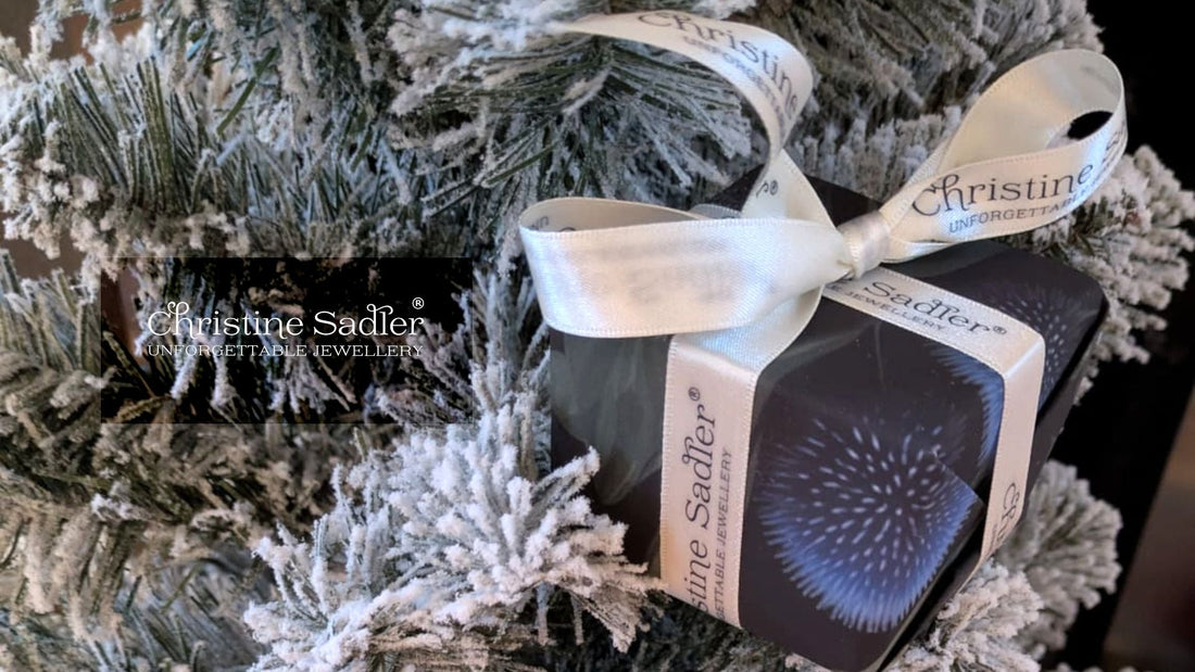 picture of Christine Sadler's stunning jewellery gift wrapped on a Christmas tree branch with branded ribbon