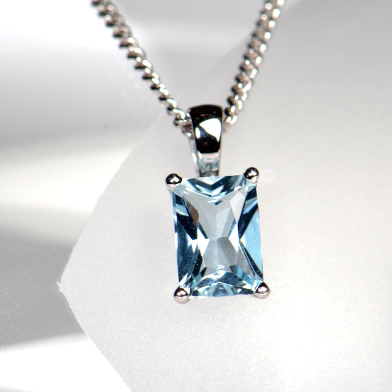 radiant cut aquamarine in a four claw white gold pendant on a white gold chain made in the UK
