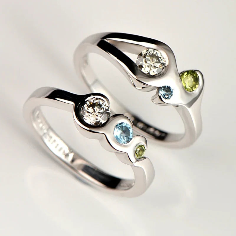 diamond, peridot and aquamarine white gold engagement rings set with the couple's birthstones in a fire and water design - Christine Sadler