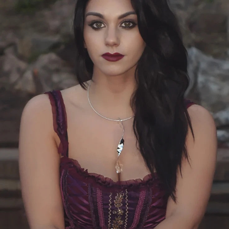 large twisted silver necklace by jewellery designer Christine Sadler worn by dark haired model wearing a gold embroidered burgundy corset