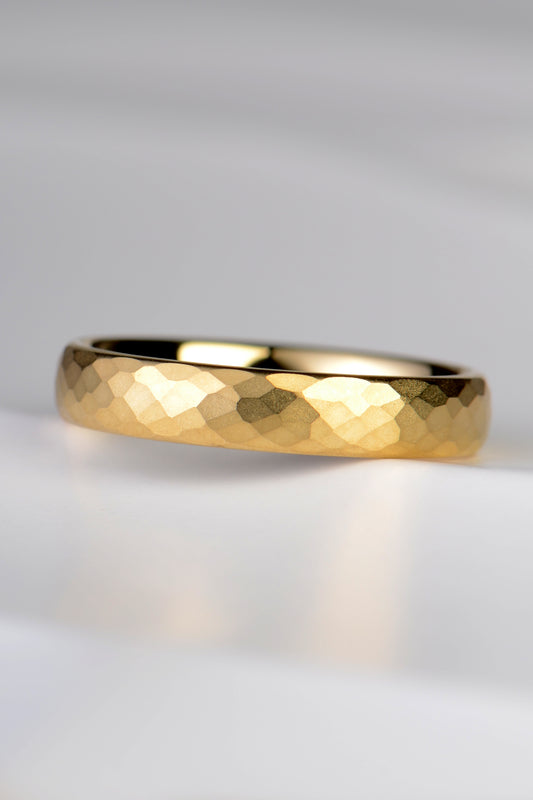 an 18 carat yellow gold wedding ring that is modern and different with a hammered texture and brushed finish