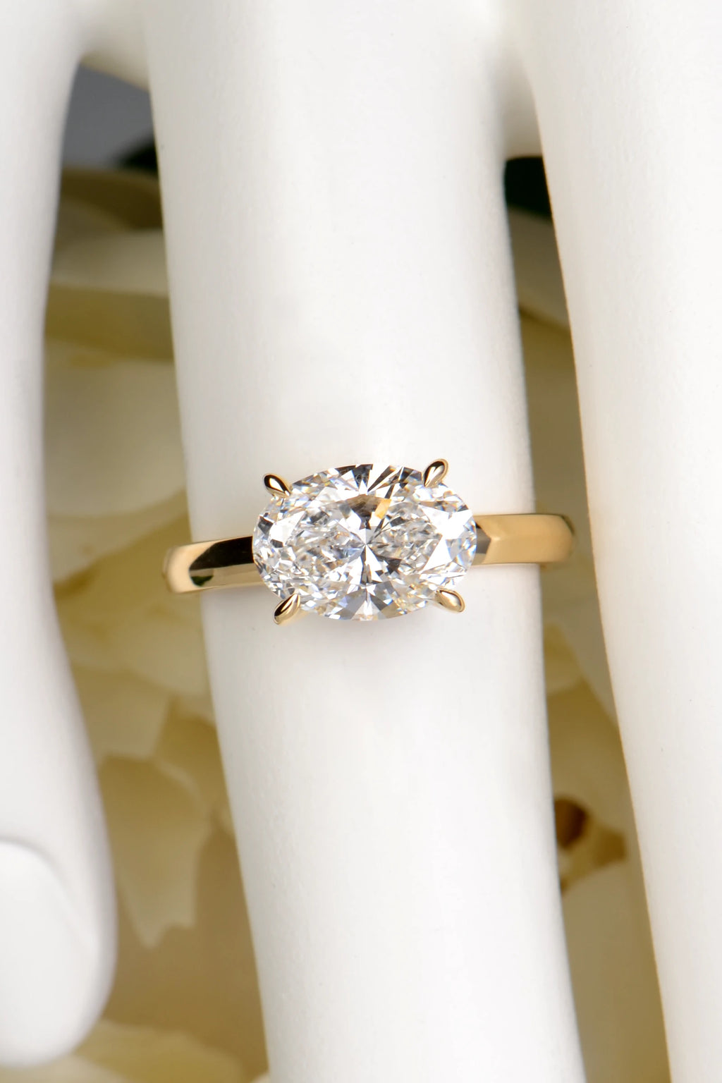 2ct oval east west lab diamond ring crafted in the UK from 18ct yellow gold shown on a finger to demonstrate size and scale.