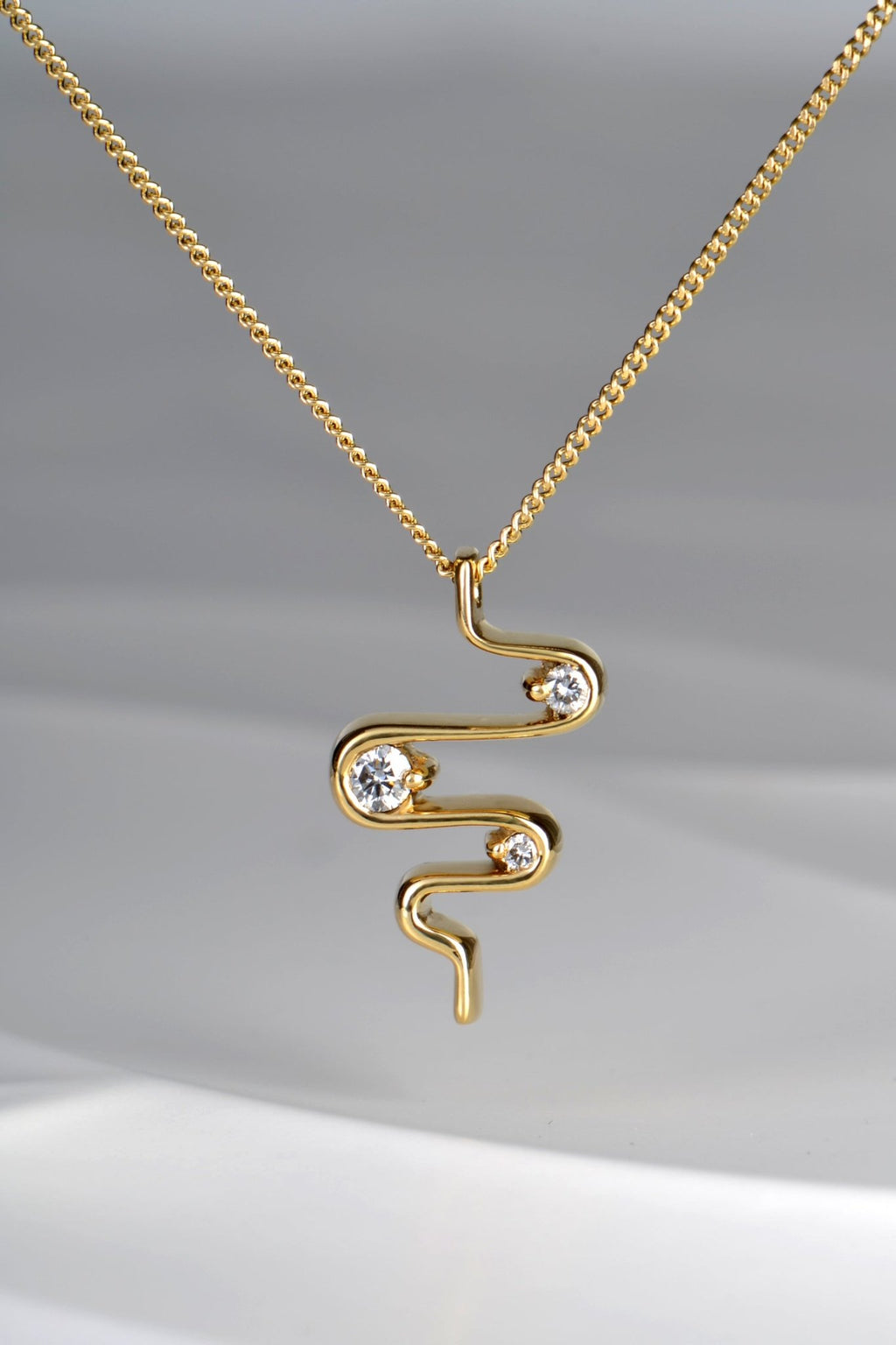 close up of 18ct yellow gold heartbeat three stone diamond designer pendant on 45cm chain