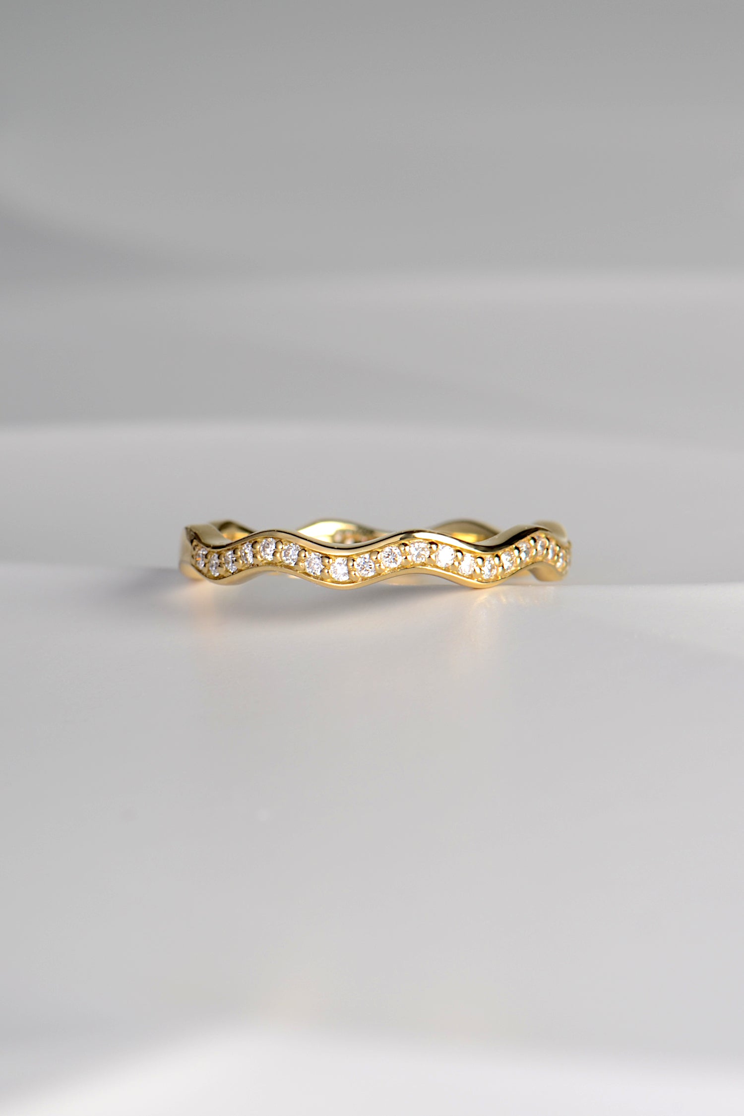 narrow 18ct gold diamond set wavy ring that can be stacked with other rings