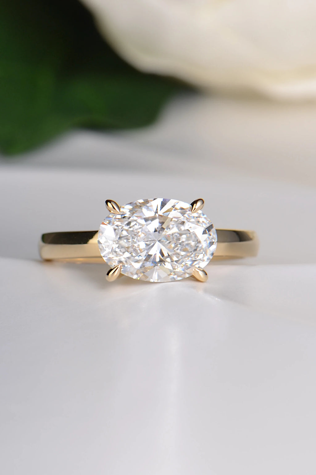 2ct oval lab grown diamond set in an 18ct yellow gold east west ring design with four talon claws.