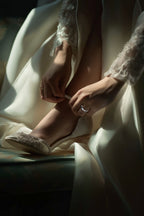 4mm platinum wedding ring shown on bride's hand as she puts on her shoes