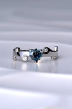 heart cut natural real colour change Alexandrite gemstone ring in a teal colour in natural light in a hearts on fire unique design by Christine Sadler
