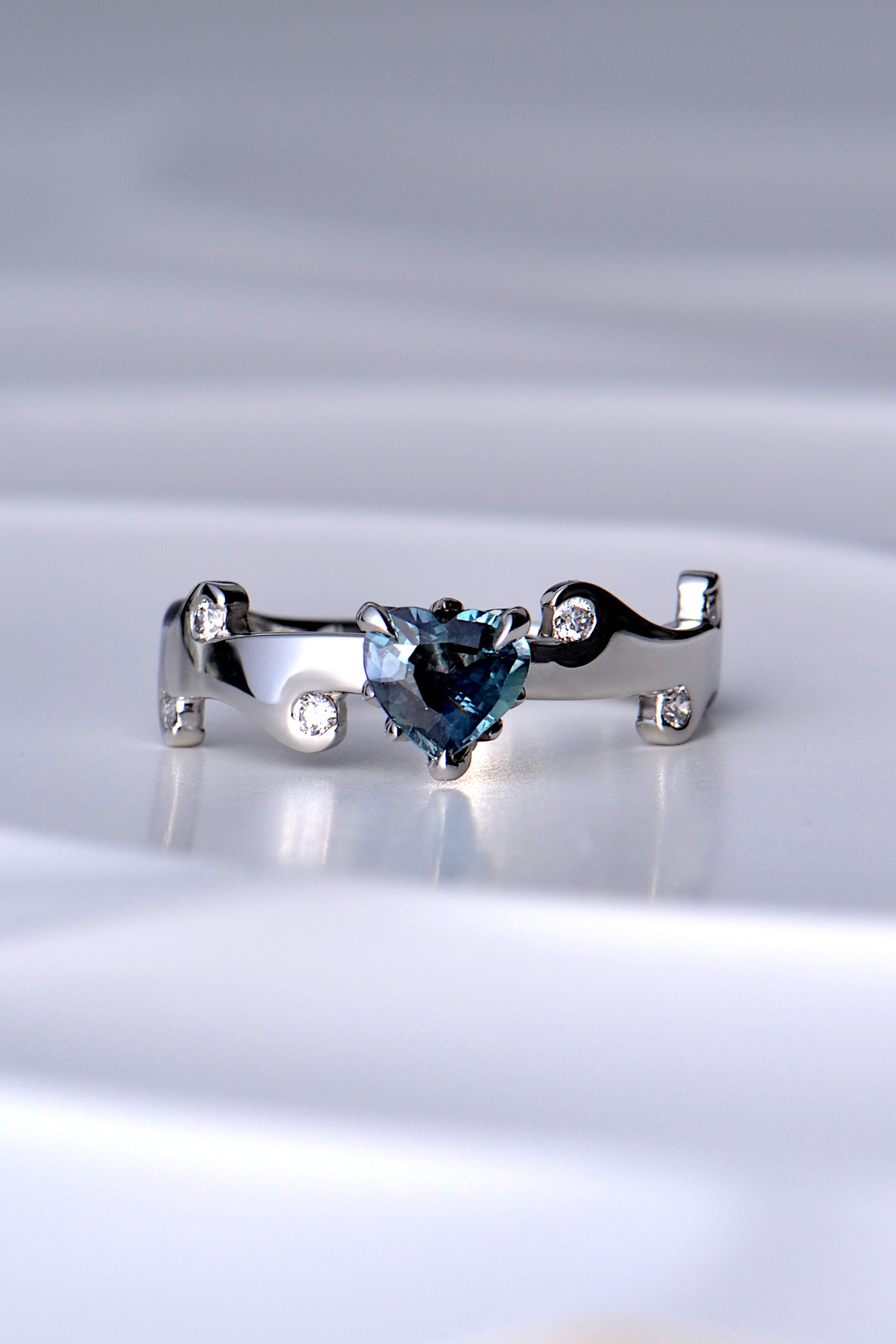 heart cut natural real colour change Alexandrite gemstone ring in a teal colour in natural light in a hearts on fire unique design by Christine Sadler