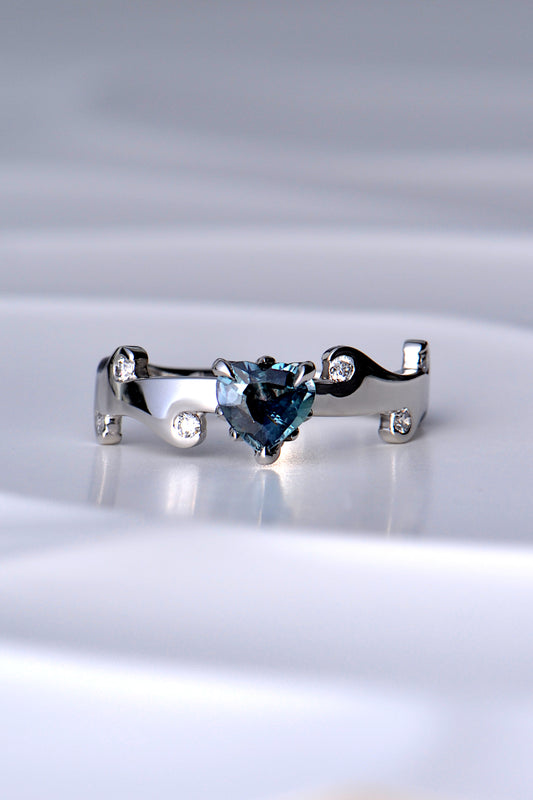 heart cut natural real colour change Alexandrite gemstone ring in a teal colour in natural light in a hearts on fire unique design by Christine Sadler