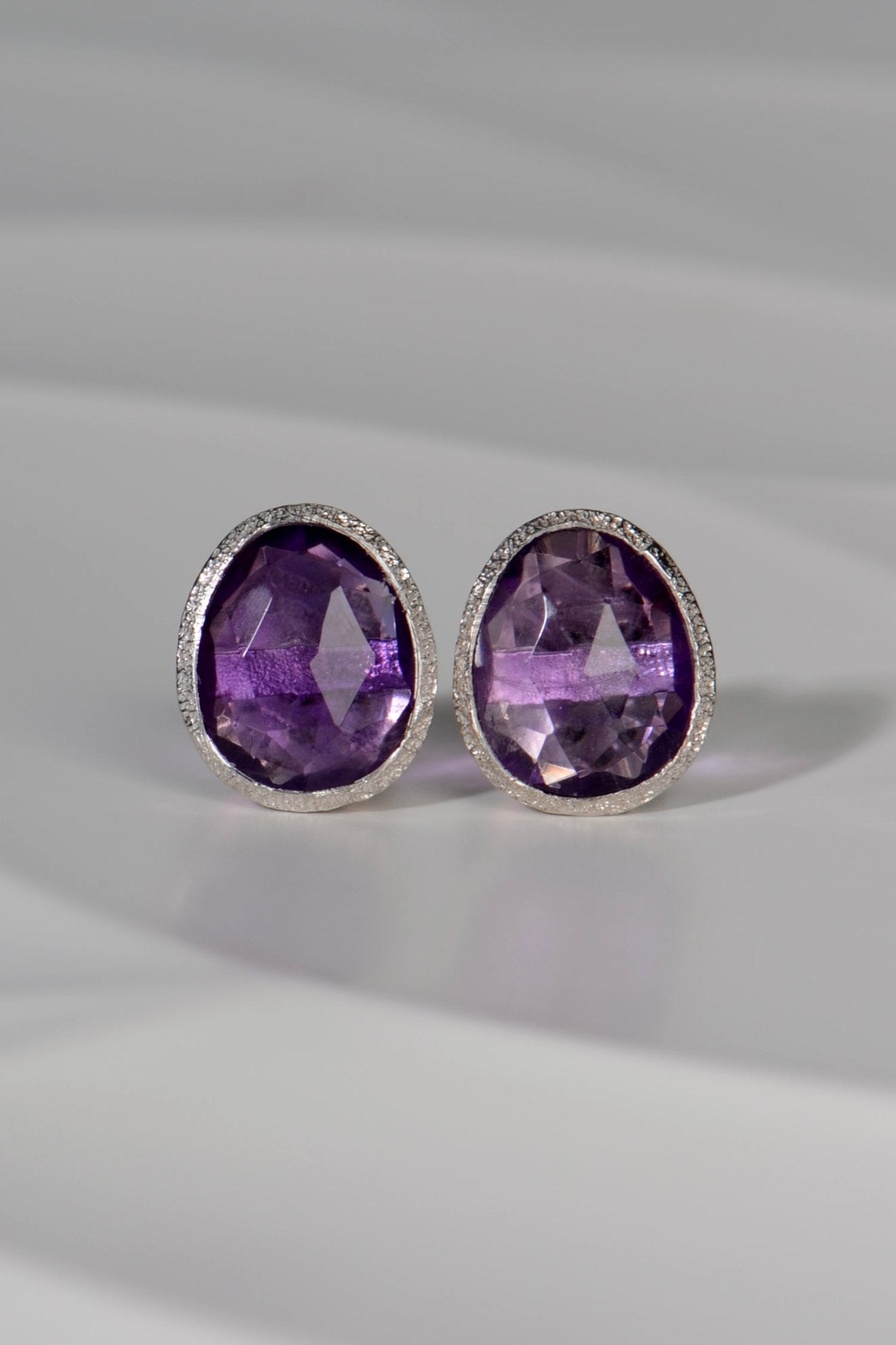 Pair of silver and amethyst birthstone earrings with polished silver backs