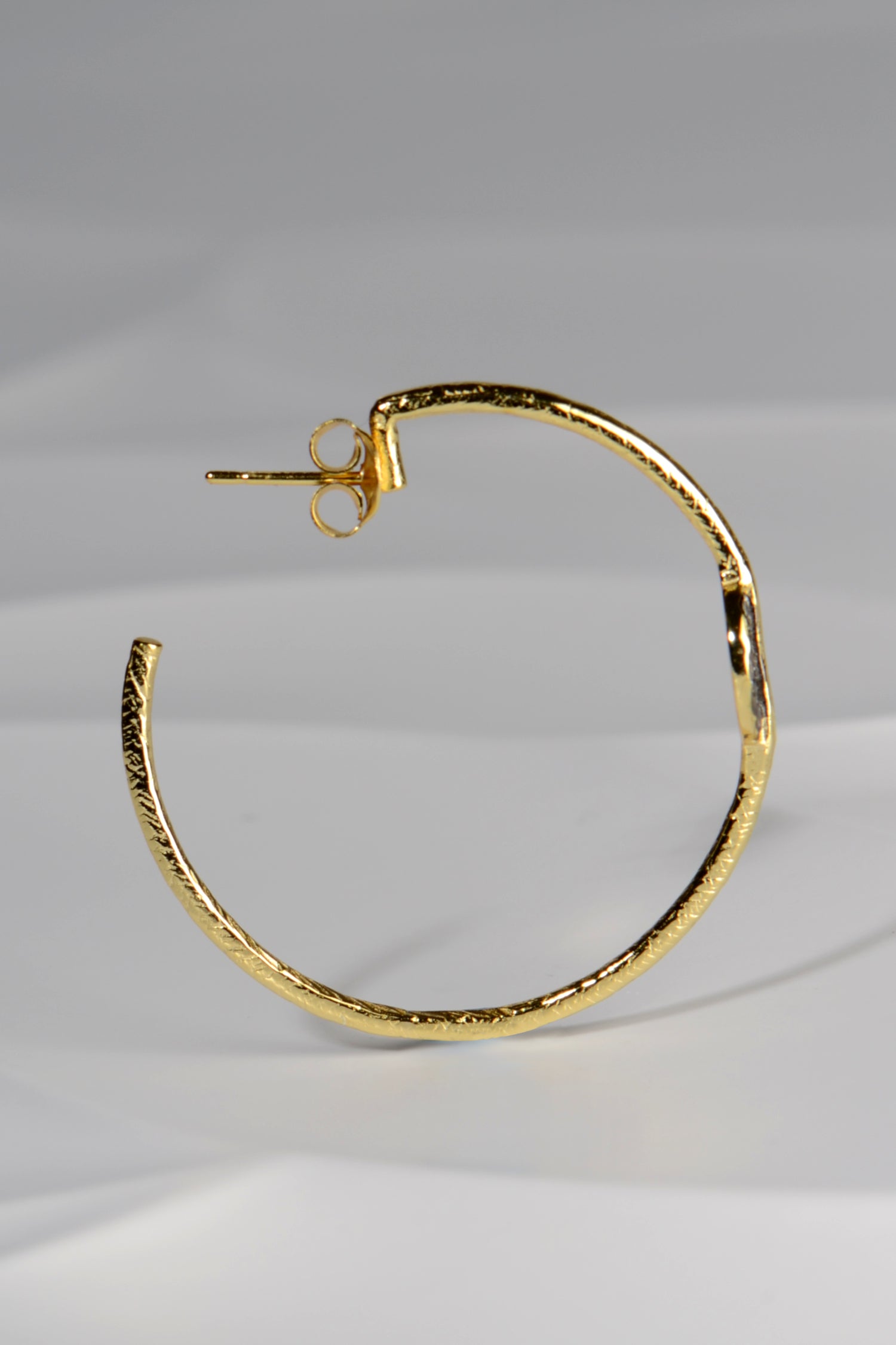 large designer hoop earrings in gold plated silver with an earring post and back fitting by jewellery designer Jorge Revilla