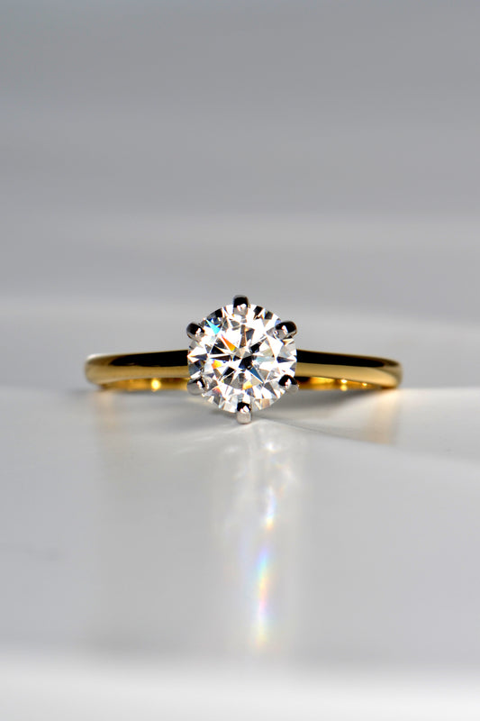 ethical six claw round brilliant cut one carat moissanite engagement ring with an 18ct yellow gold band and an 18ct white gold setting