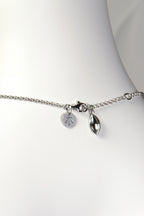 sterling silver modern necklace with a seed shaped charm detail that hangs at the clasp. Christine Sadler