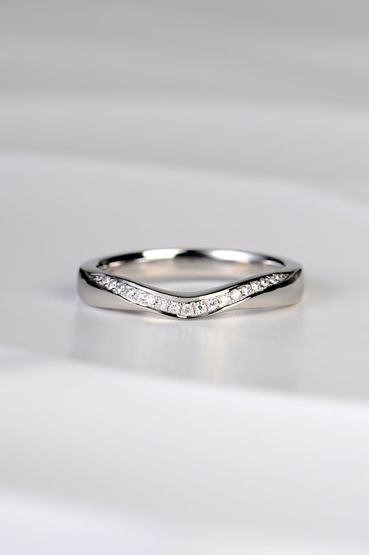 U shaped wedding ring that dips at the front in a sculptural carved way and which has a ribbon of brilliant cut diamonds following the curve