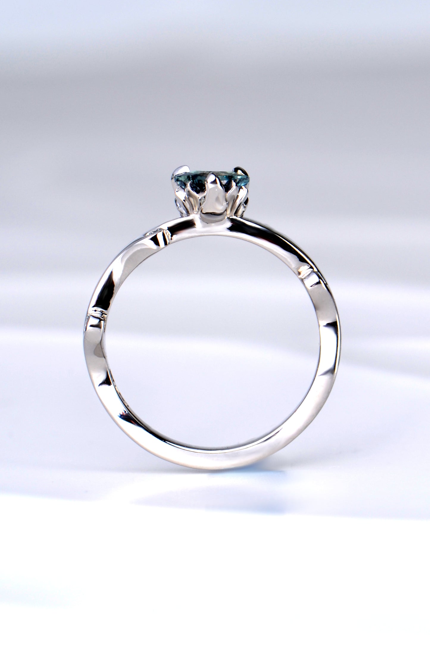 side view of the platinum and diamond heart cut Alexandrite colour change ring showing the sculptural design of the tiny flames that rise up to hold the gemstone